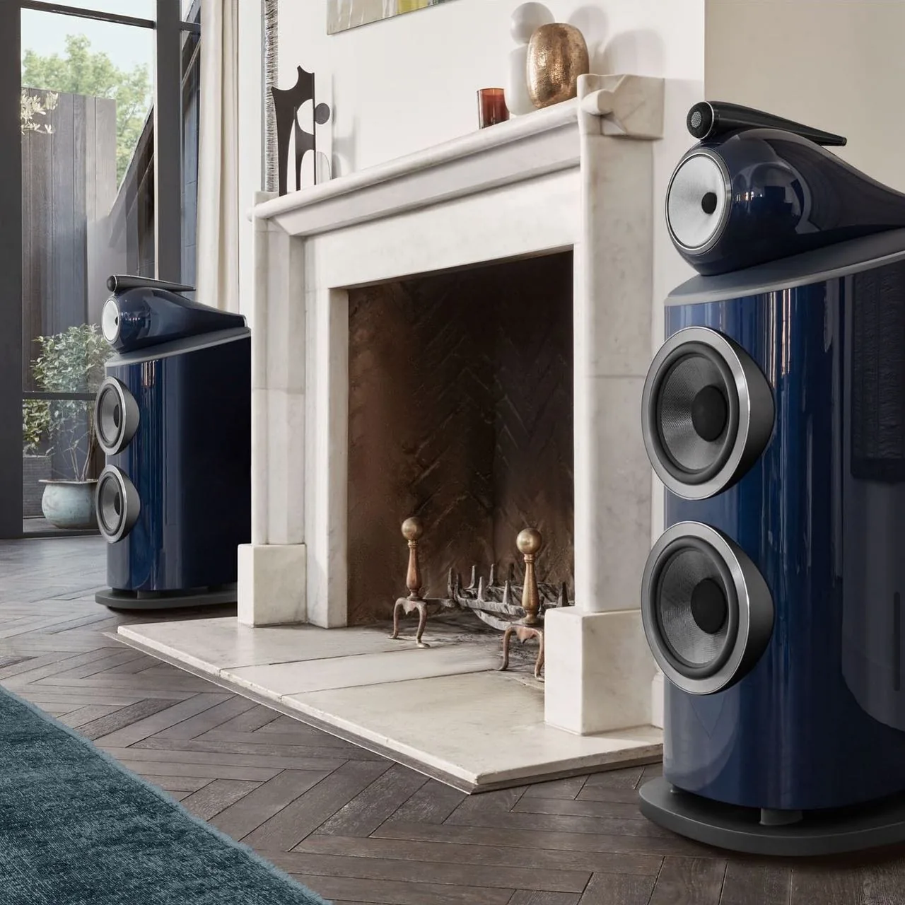 A pair of Bowers & Wilkins 800 series speakers either side of a marble fireplace