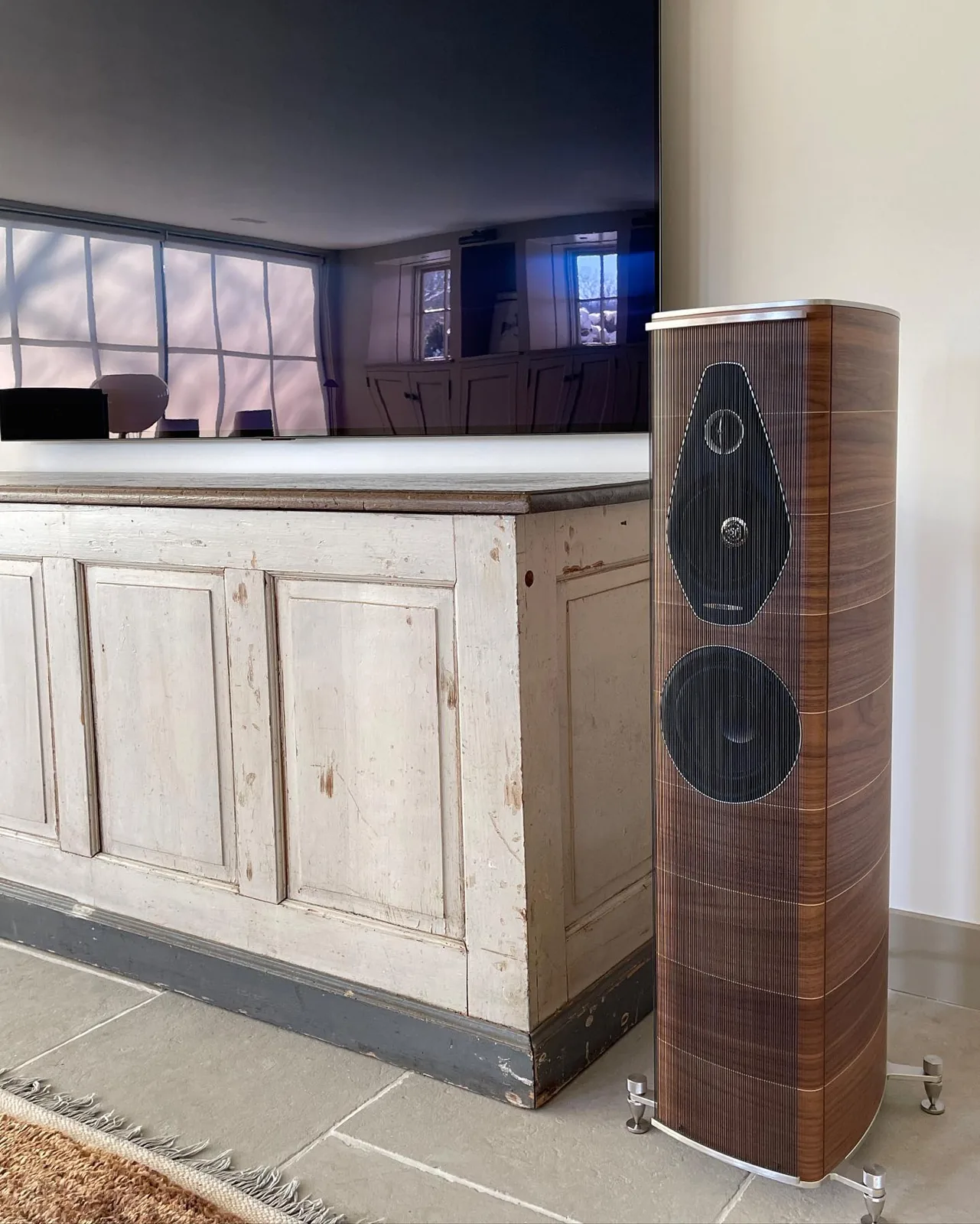 A walnut Sonus faber floorstanding speaker beside a painted console