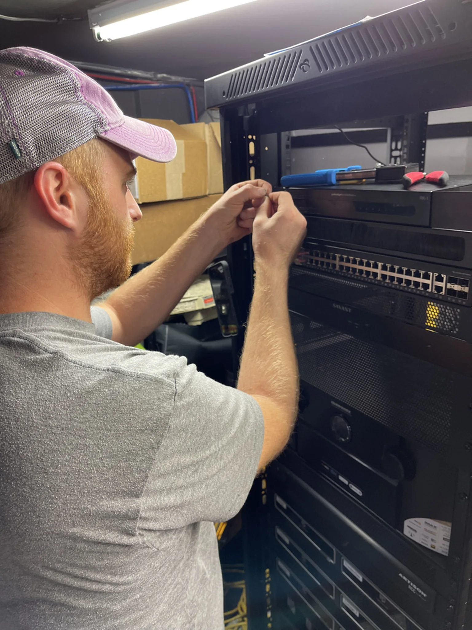 One of our technicians dressing cable in a Savant equipment rack