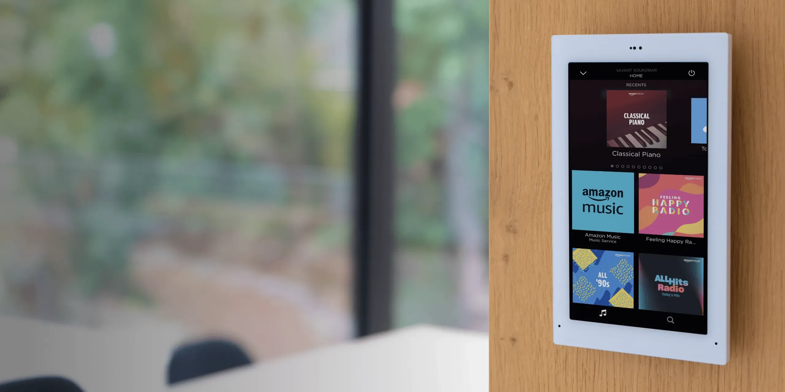 A Savant touch panel set into a wall beside a window