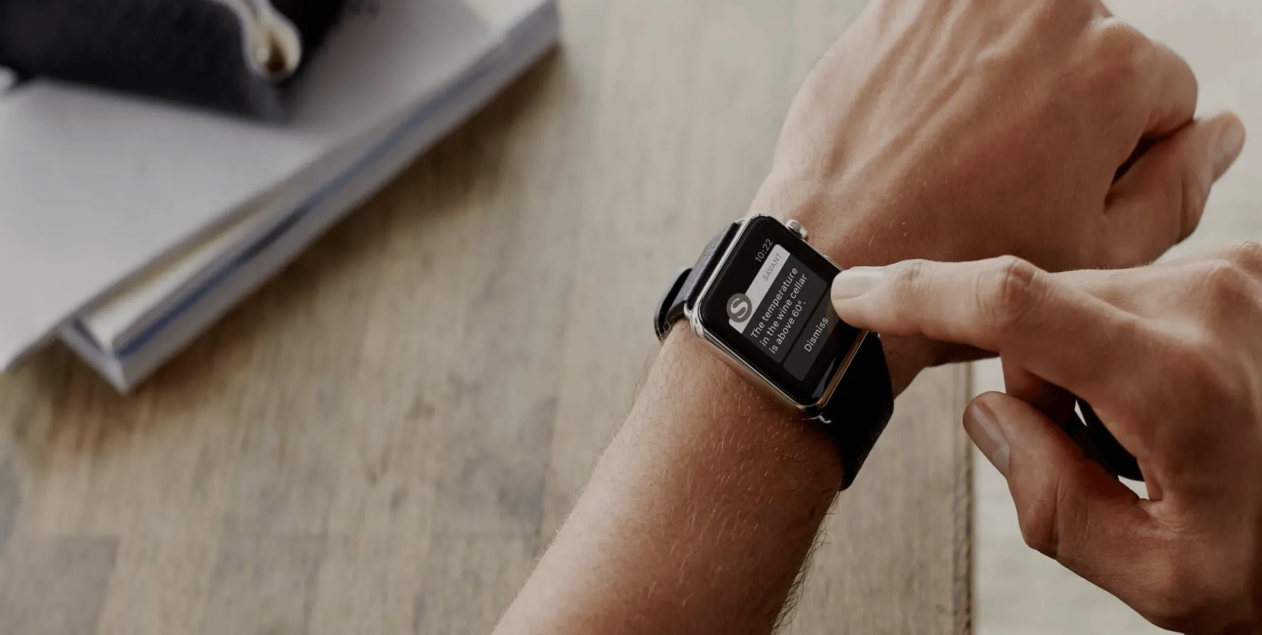 The Savant app on an Apple Watch, a finger about to tap it