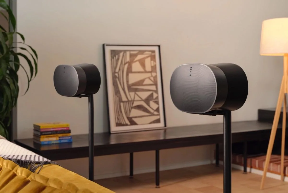A pair of black Sonos Era 300 speakers on stands in a living room